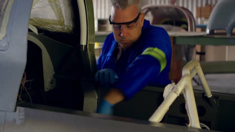 ingeniero arreglando una aeronave en el hangar 4k