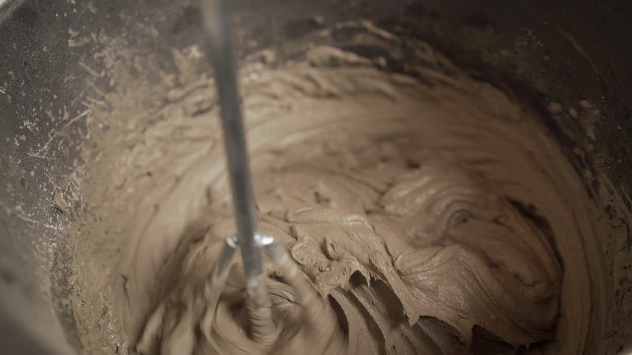Stir the tile adhesive in the bucket. The worker mixes the solution in a bucket.