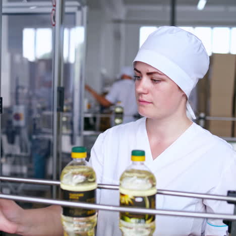 interior of automated factory of refined oil production. female worker in uniform controls the work of modern equipment. sunflower oil plant.
