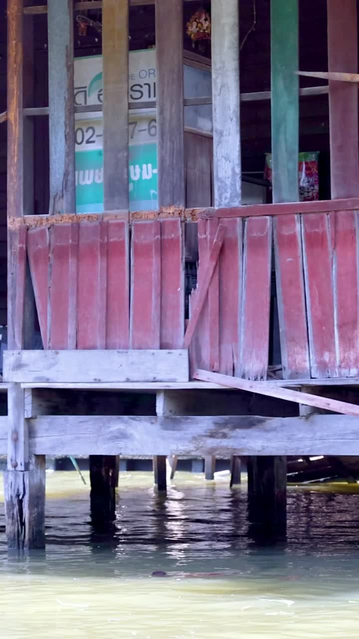 방의 운하를 따라 세련된 목조 집의 조용한 풍경, 전통 건축물과 울창한 초록색을 보여줍니다.