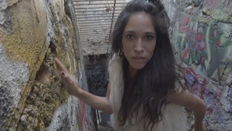 high angle of a woman with long dark hair intensely staring into the camera lens and walking up the steps