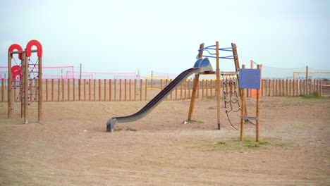 Empty playground at the beach, no children playing, deserted during the Covid-19 pandemic lockdown, on a cloudy day