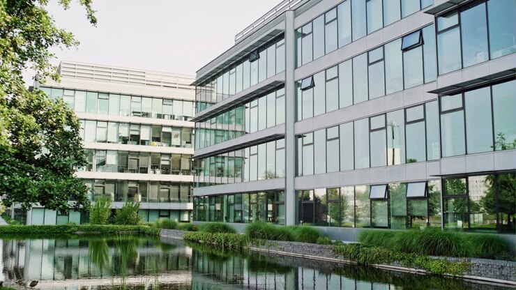 Pond with trees in front of modern contemporary glass office building