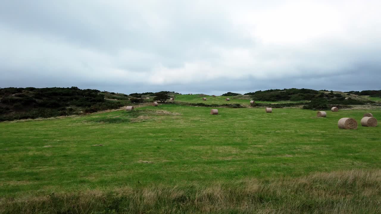 열린 흐린 영국 농지에서 압연 짚 건초 베일과 시골 고원 초원