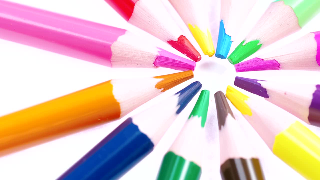 los lápices multicolores de los niños giran sobre un fondo blanco.