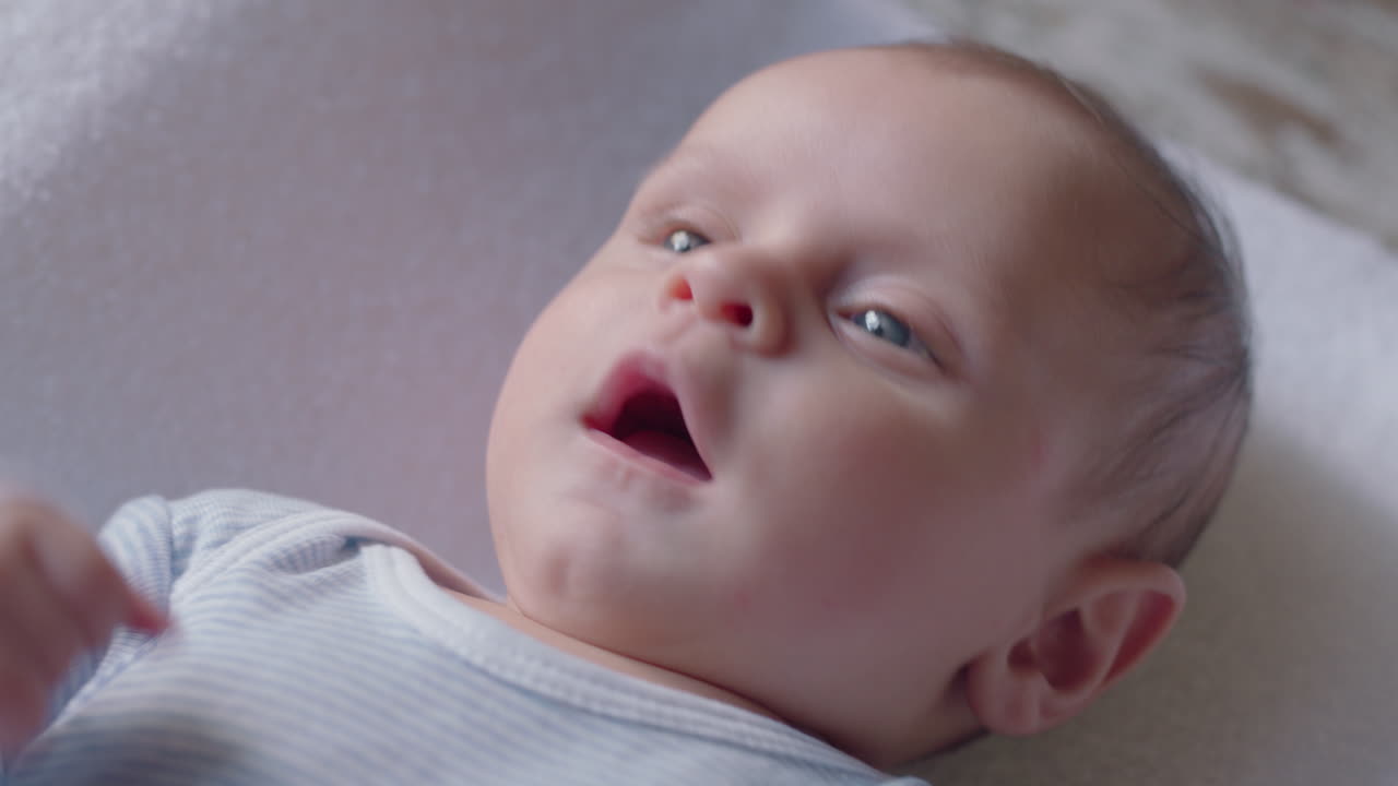 retrato de bebê bonito procurando bebê curioso deitado em um cobertor