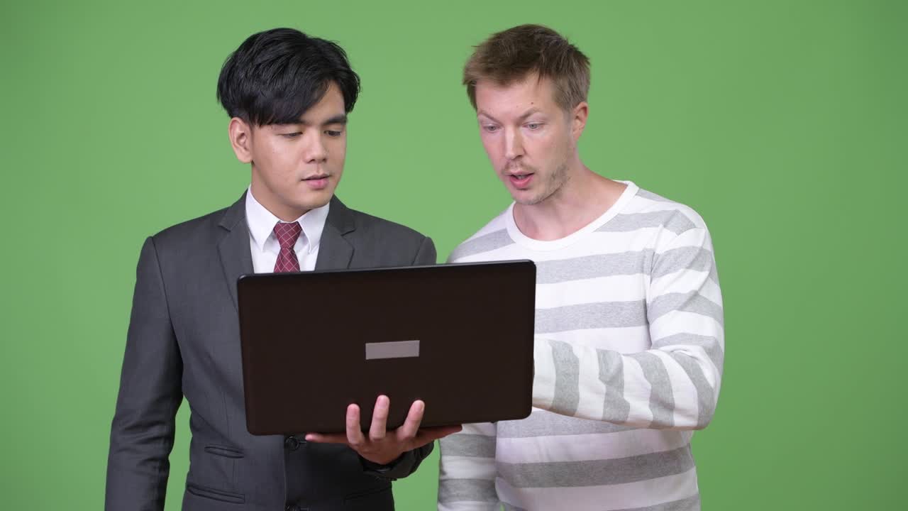 젊은 잘생긴 아시아 사업가와 젊은 스칸디나비아 사업가가 함께 일하고 있습니다.