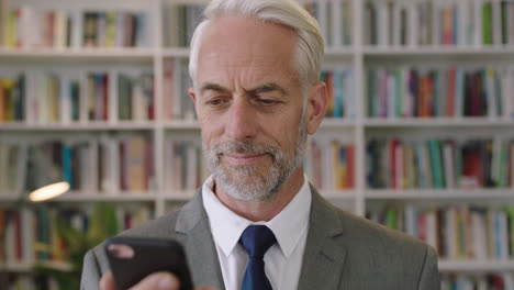 portrait-of-professional-businessman-using-smartphone-in-library-office-smiling-gentleman-architect-professor-lecturer