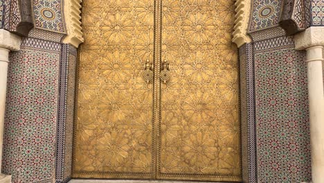 beautiful entrance gate to the royal palace with mosaic and brass door in fez, morocco