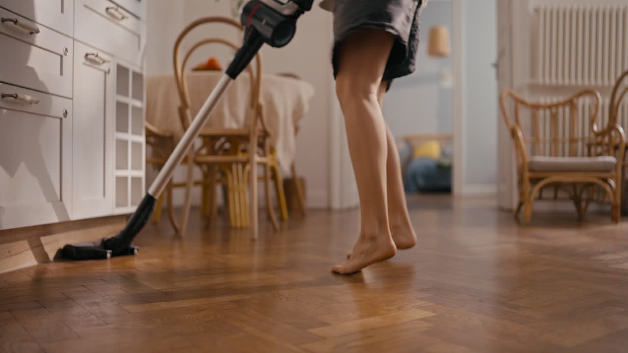 Woman Vacuuming Parquet Floor at Home