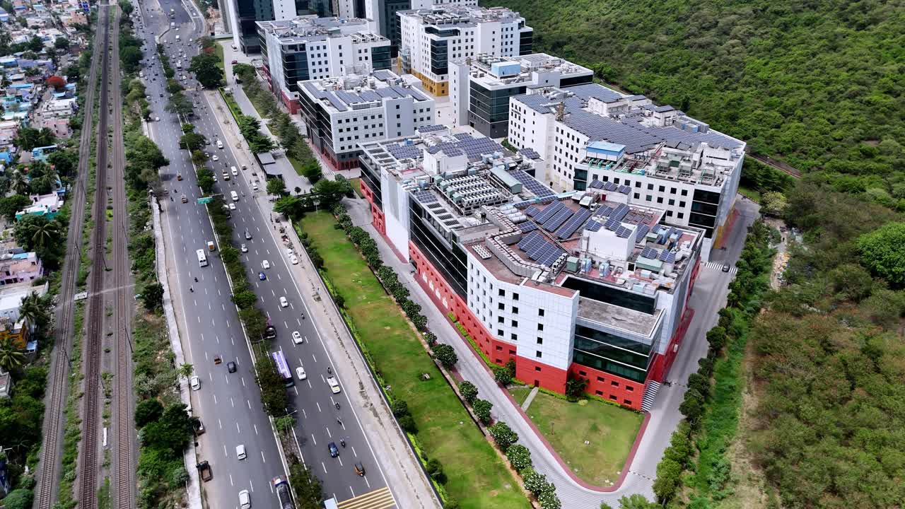 Corporate Innovation Hub: Elevated shot showcasing a sleek business complex with white, glass, and orange facades. The campus emphasizes sustainability with large solar arrays visible on the roofs