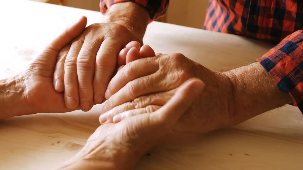 Casal sênior, segurando as mãos uns dos outros