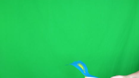 primer plano de una mano desconocida sosteniendo una bandera de kazajstán en un fondo de pantalla verde en el estudio. grabado en resolución 4k