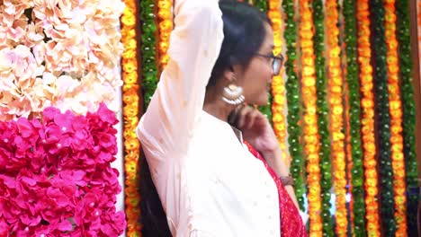 side view of pretty indian girl wearing eye glasses and big earrings with colorful garlands in main hindu festival 'diwali' celebration in agra, india - medium shot