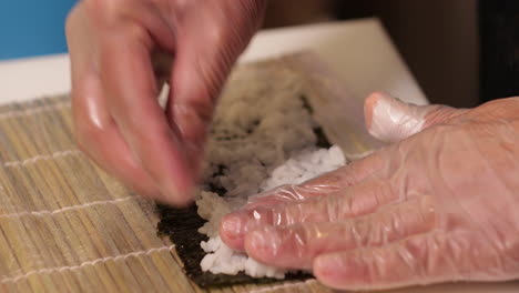 putting and arranging rice for a delicious kabuki sushi roll - slow motion