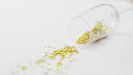 vaso de champán y confeti sobre fondo blanco en la víspera de año nuevo