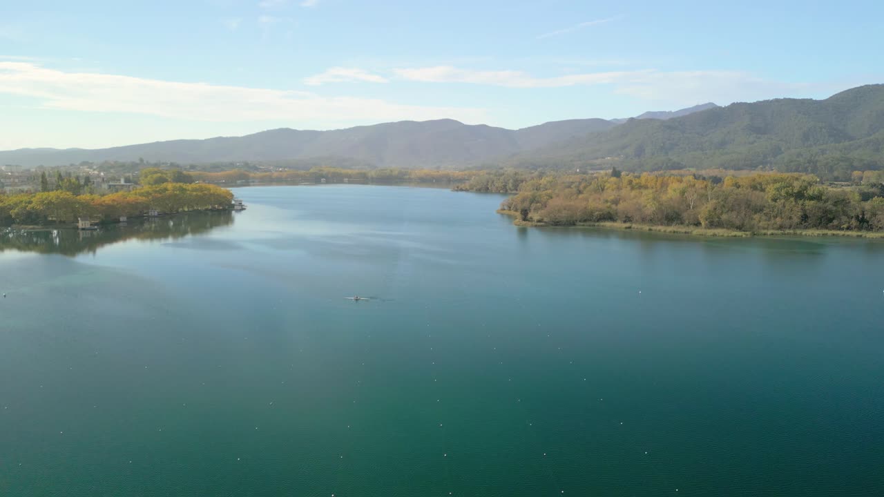 Serene Lake with Rower and Autumnal Foliage