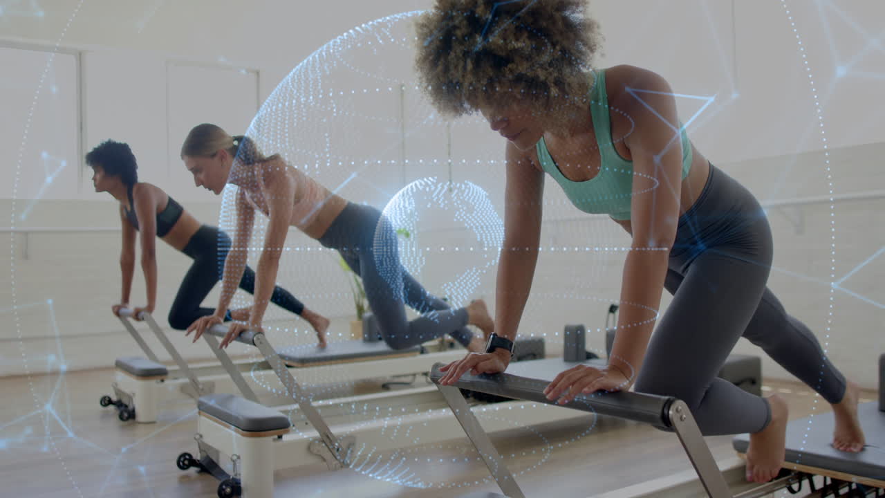 Exercising on reformers, women with digital network animation overlay in gym