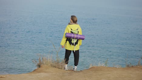 rear view of a male tourist delighting sea view during hiking on mountain trail