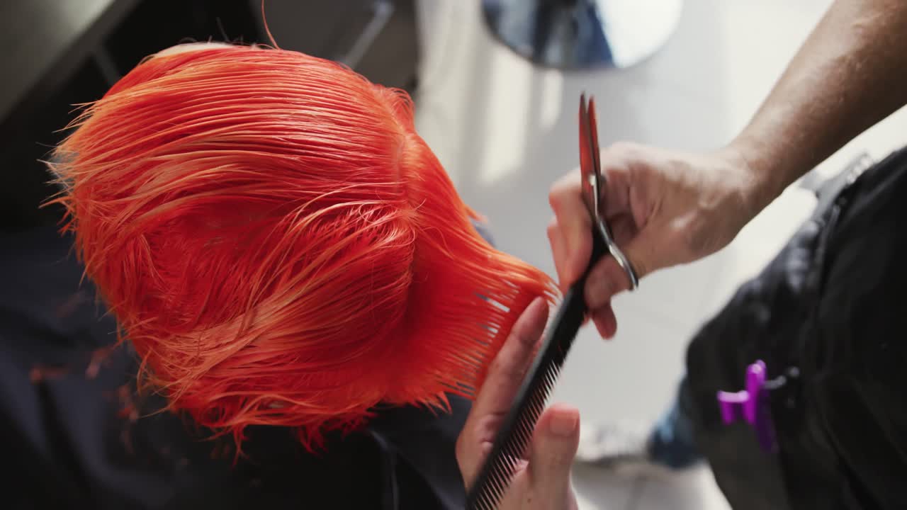 높은 각도 뷰 여성이 이발사에 의해 머리카락을 자르고 있습니다.