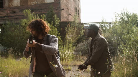 men with guns around an abandoned house