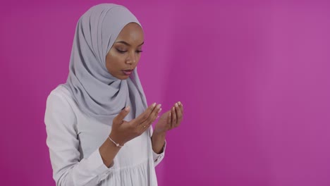 modern african muslim woman makes traditional prayer to god over colorfull background