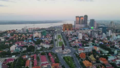 aerial flyover phnom penh with independence monument and mekong river during dusk