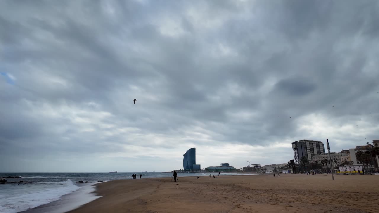 Panoramic shot of Barceloneta Beach and the Mediterranean Sea during a cloudy afternoon in the city of Barcelona, Spain