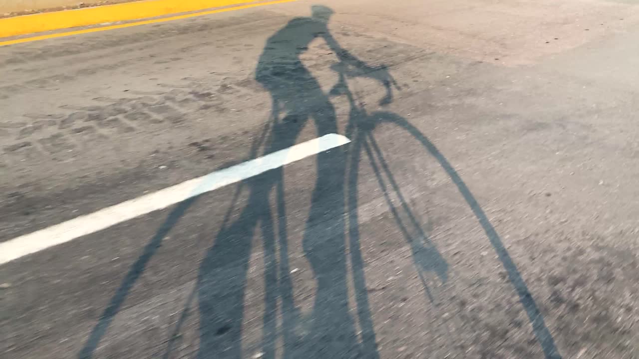 아스팔트 훈련에서 도로 자전거를 타는 자전거 타는 사람의 그림자, 관점