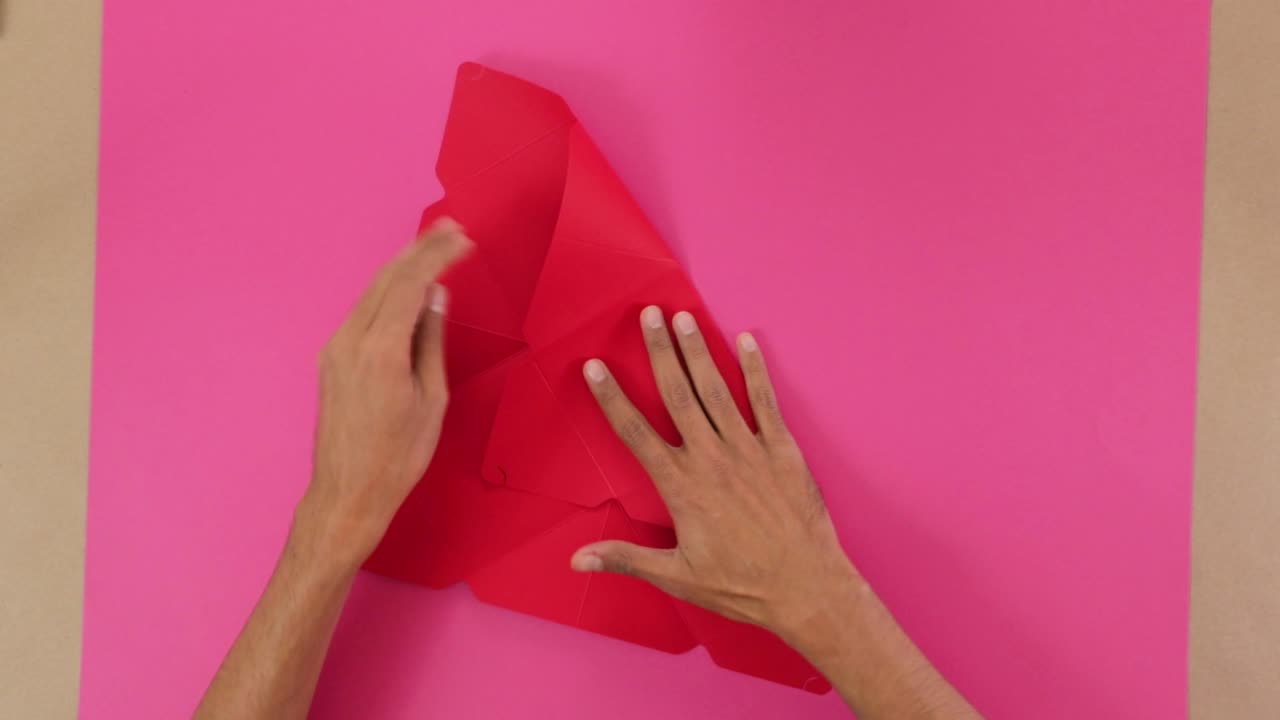 Marking fold marks on red hard paper for origami on pink paper