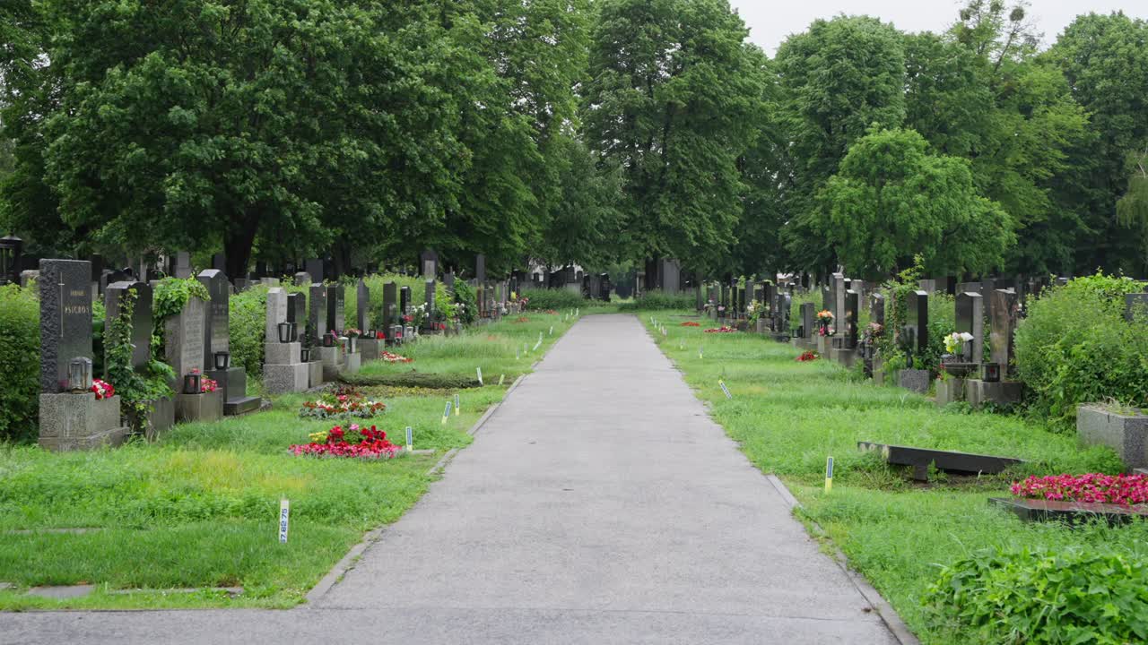 La camera scorre lungo il sentiero tra le lapidi nel cimitero di Vienna
