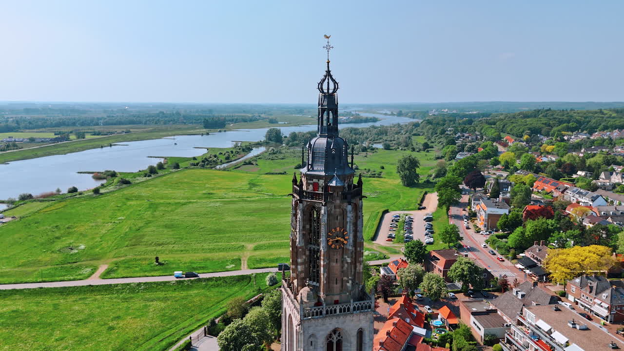 Top of the clock tower of the Cunera Church in the city of Rhenen, Province Utrecht, the Netherlands. Picturesque cityscape on sunny day at backdrop.