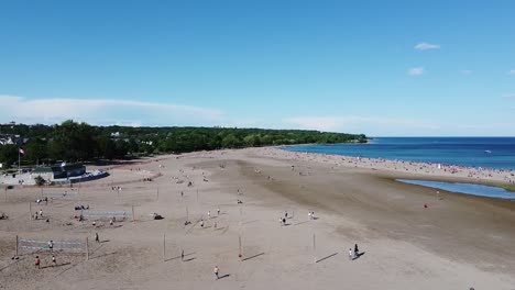 flying over people playing volleyball on a toronto beach on lake ontario in the summer