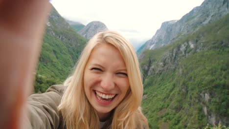 4k video footage of an attractive young woman recording a video during her hike in naeroydalen valley