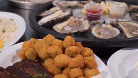 a variety of seafood platters, blackened fish and okra, a dozen raw oysters on the half shell, close up slider 4k