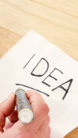 man having a cup of black coffee while writing on piece of paper