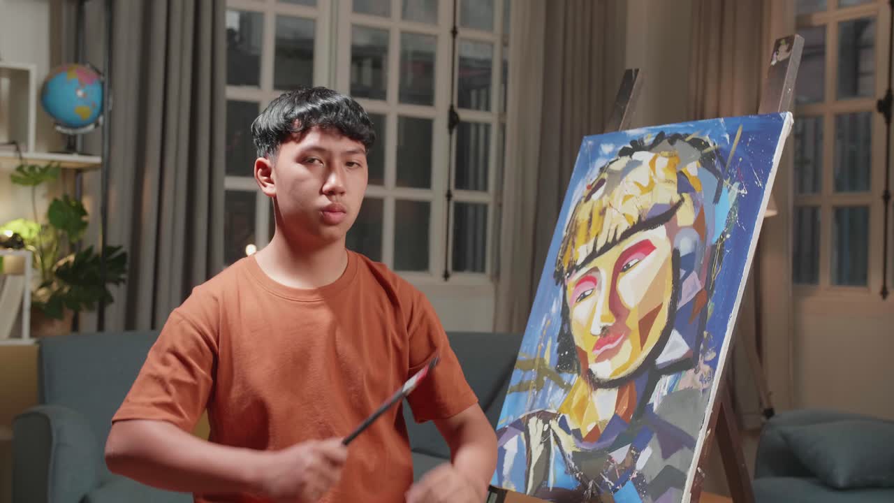 Asian Artist Boy Holding Paintbrush Mixed Colour Wipe The Sweat Before Crossing His Arms And Smiling After Finish Painting A Girl On The Canvas