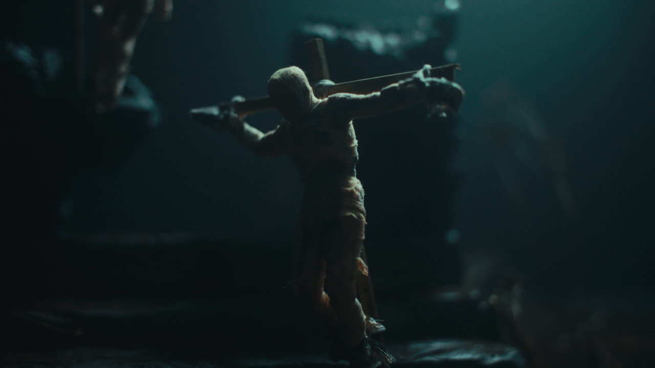 A miniature mummified doll hanging on the gallows at night