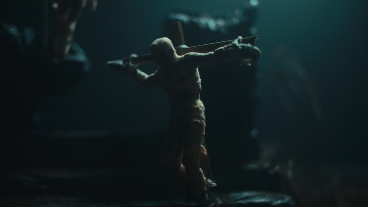A miniature mummified doll hanging on the gallows at night