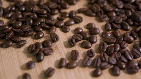 Close-Up-Of-Roasted-Coffee-Beans-on-Wooden-Surface