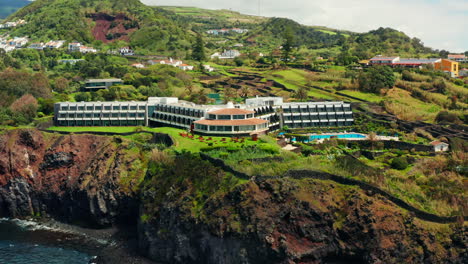 Cinematic-aerial-drone-shot-of-a-beautiful-resort-located-on-top-rocky-coastline-in-Sao-Miguel-island,-Azores---Portugal