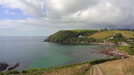 panning view over the secluded beaches of talland bay in cornwall