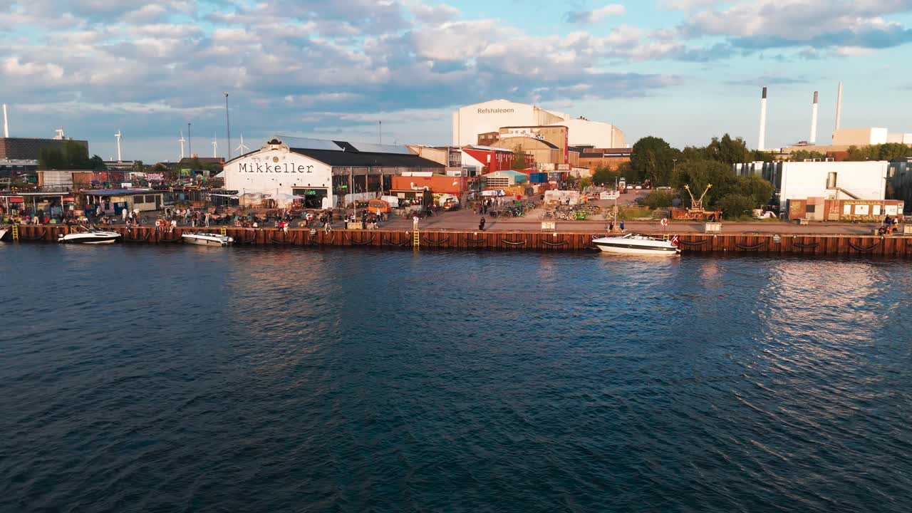 Aerial approach above water toward Reffen street food market, Copenhagen