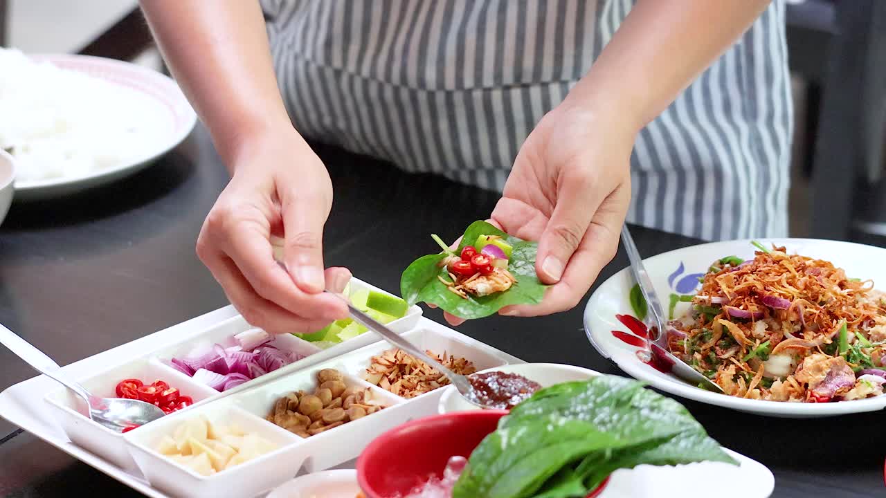 손으로 전통적인 태국 미앙 을 조심스럽게 포장하는 맛있는 잎