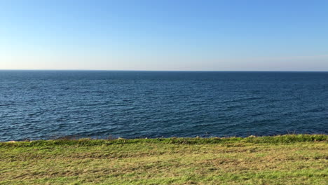 horizonte marino al borde de un campo verde