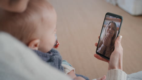 mother and baby using smartphone having video chat with best friend waving at toddler happy mom enjoying sharing motherhood lifestyle on mobile phone screen 4k