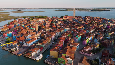 prominent fishing village with colorful houses during sunset in burano island near venice, italy. aerial drone shot