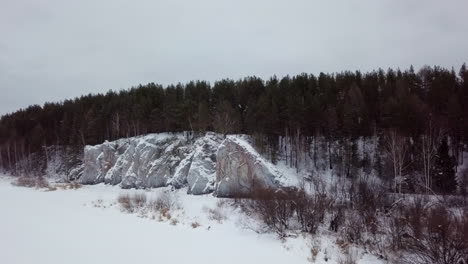 winter landscape with rocky cliffs and snow-covered forest