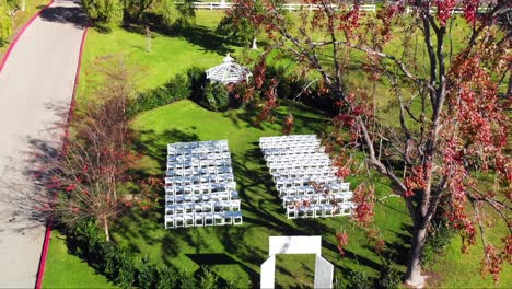 aerial drone ascending shot passing by trees showing an outdoor wedding venue