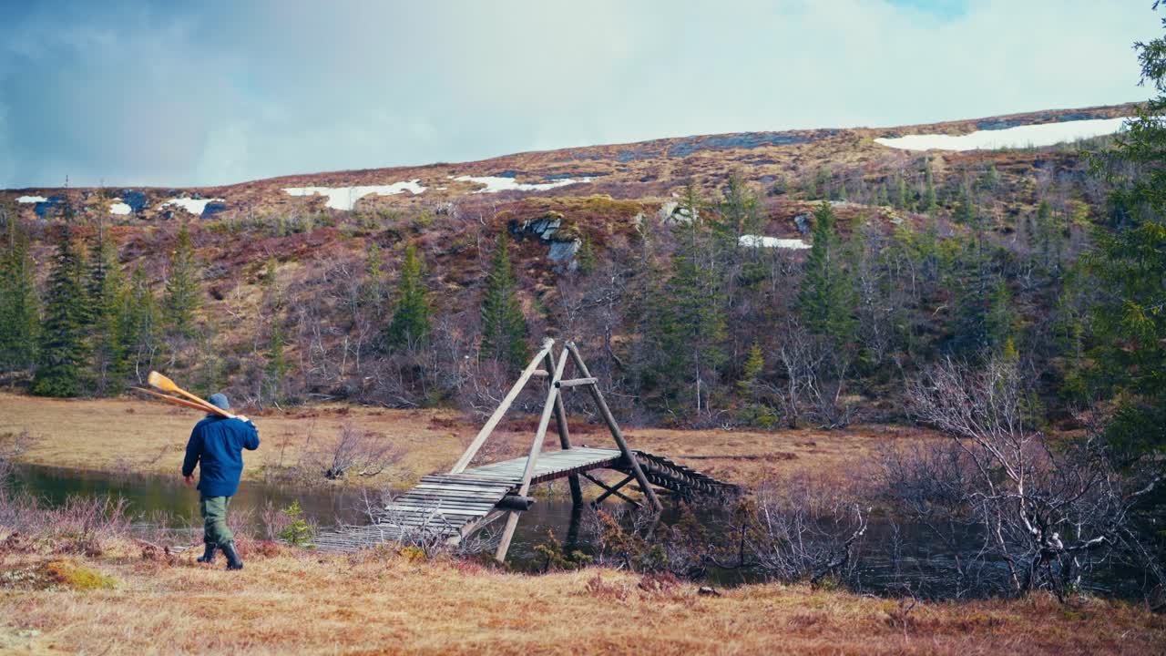 Man Walking And Carrying Oars In Åfjord, Norway - Wide Shot